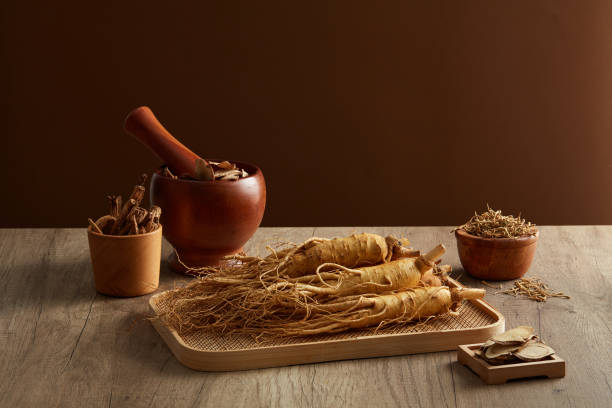 Herbal ginseng on a tray with a mortar and pestle on a wooden surface